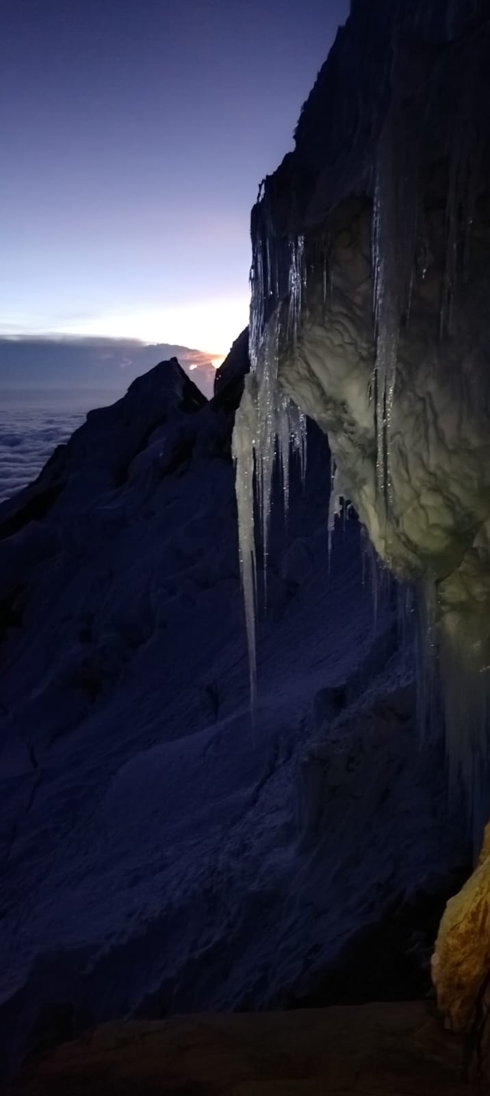 Night ascent: ice formations under a cornice